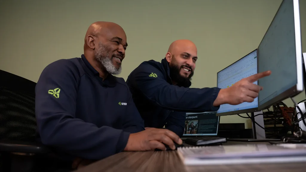 Twee engineers bekijken een planning op computer in kantoor.