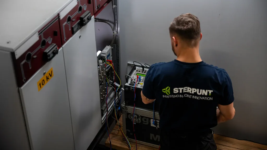 Technicus stelt een relais in op een 10 kV schakelinstallatie.