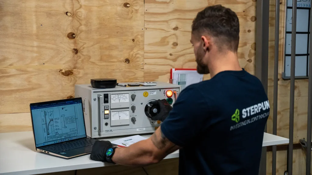 Technicus test elektrische installatie met meetapparatuur en laptop.